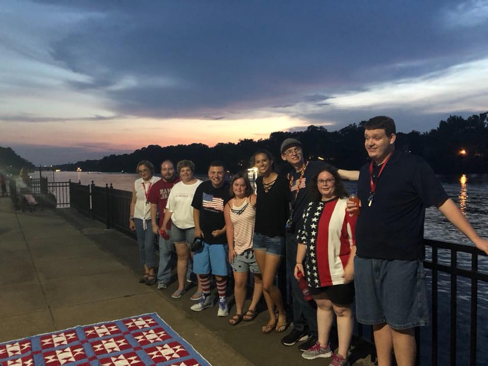 People standing in front of a river at night