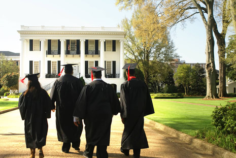 Grads walking towards white building