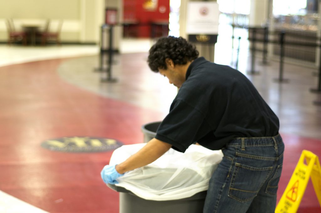 Man placing new trash bag in trash can