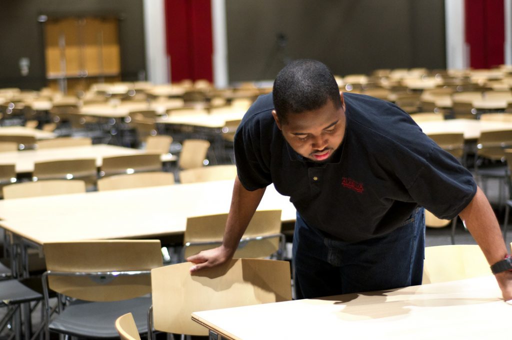 Man cleaning chairs and tables